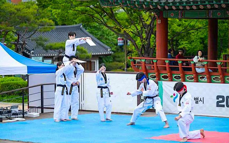 Taekwondo performers on stage at a traditional Korean venue